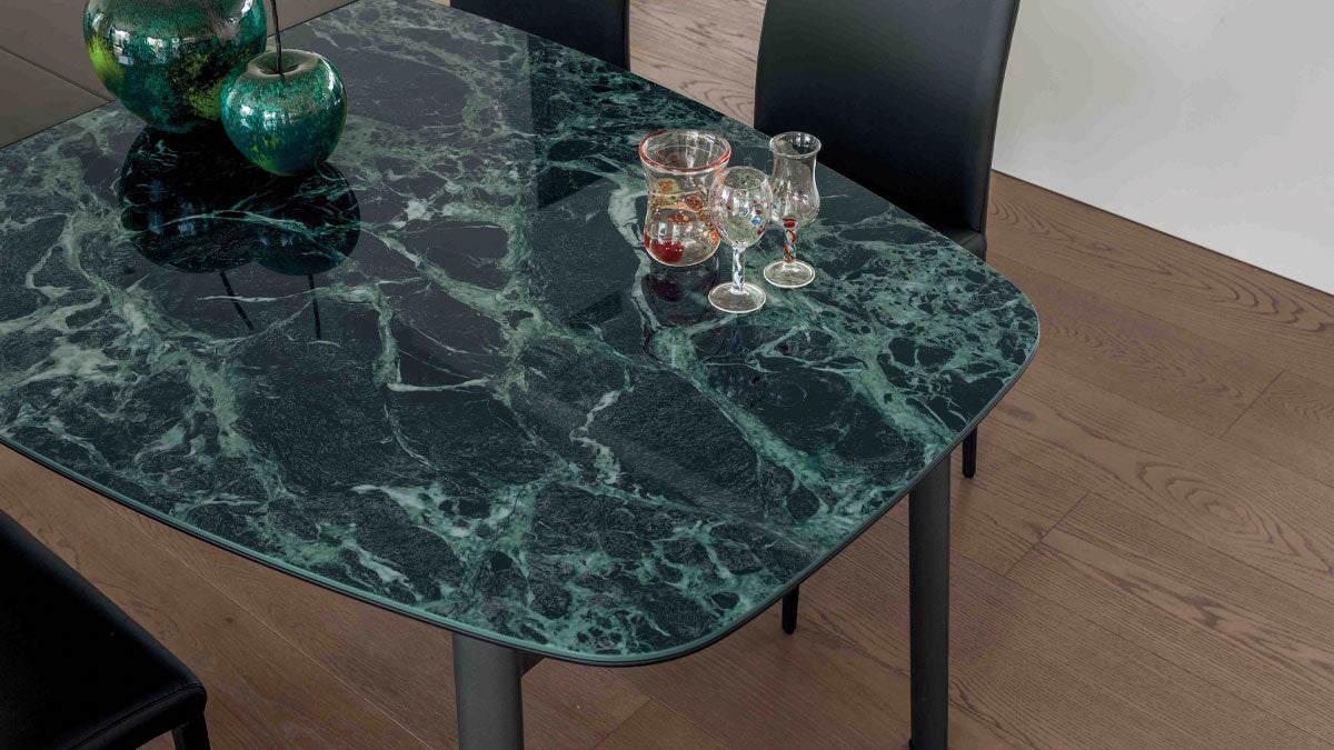 Paddington table with green marble surface and black chairs in a room.