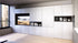 Modern foldaway table inwhite cabinets, black shelves, and a large window.
